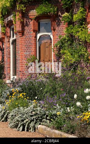 Ein englisches Herrenhaus mit vielen Blumenbeeten vorne Stockfoto