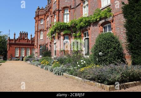 Ein englisches Herrenhaus mit buntem Blumenbeet vorne Stockfoto