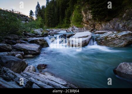 Kleiner Wasserfall durch die Felsen in den Alpen Stockfoto