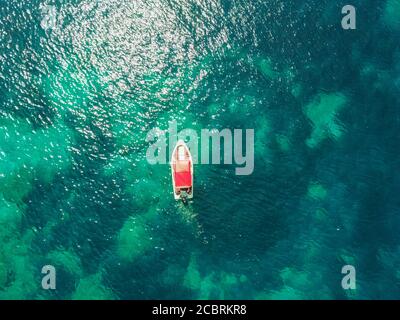 Rot-weißes Schnellboot im Meer, fotografiert von oben mit der Drohne am Strand Zarace auf der Insel Hvar, Kroatien Stockfoto