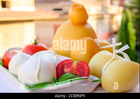 Käsesammlung, italienische Käse provolone, caciocavallo, scamorza, Mozzarella Büffel aus Süditalien, weiß und gelb geräuchert, serviert im Freien in Stockfoto