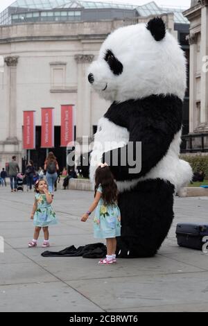 London, Großbritannien. August 2020. Kinder lassen sich mit einem Panda auf dem Trafalgar Square fotografieren. Kredit: Liam Asman/Alamy Live Nachrichten Stockfoto