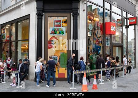 London, Großbritannien. August 2020. Vor dem Lego Store am Leicester Square stehen die Menschen Schlange, wenn nach mehreren Tagen der Hitzewelle im Sommer kühleres Wetter in London einbricht. Kredit: Liam Asman/Alamy Live Nachrichten Stockfoto