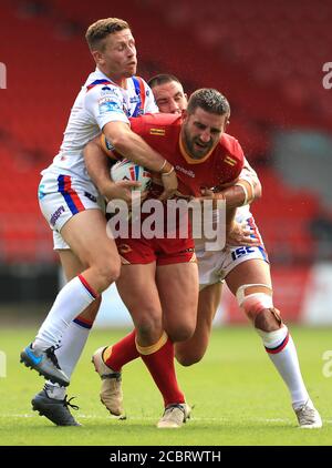 Julian Bousquet von Catalans Dragons (Mitte) wird von Kyle Wood von Wakefield Trinity (links) und Romain Navarrete während des Betfred Super League-Spiels im total Wicked Stadium, St. Helens, angegangen. Stockfoto