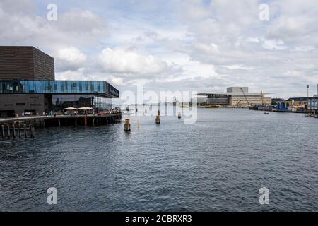 Kopenhagen, Dänemark - 2. August 2020: Das Schauspielhaus links mit dem Opernhaus im Hintergrund. Dies ist ein beeindruckendes, zweckgebautes Theater für Theaterstücke, plus elegantes Dining mit Hafen- und Stadtblick Stockfoto