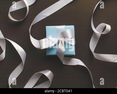 Blaue Geschenkbox mit weißem Band Stock Bild. Stockfoto