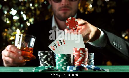 Poker-Spieler werfen roten Chip. Konzept des Hazard Gaming, Pokerchips auf dem Tisch Stockfoto