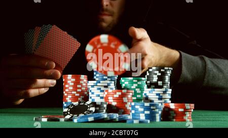 Poker-Spieler werfen roten Chip. Konzept des Hazard Gaming, Pokerchips auf dem Tisch Stockfoto