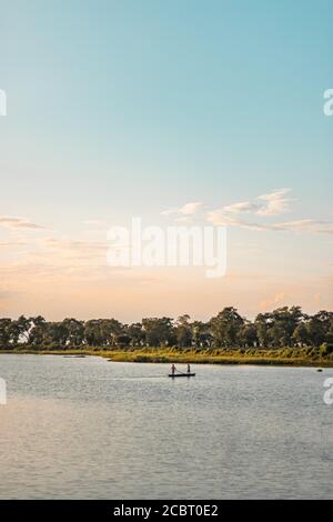 Assam, indien - 12. August 2020 : Bootsmann mit einer schönen Landschaft an der goldenen Stunde. Stockfoto