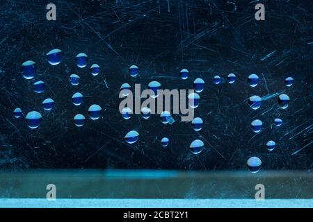 Wort beängstigend von Wassertropfen auf der Oberfläche von Eine geheimnisvolle Atmosphäre aus zerkratztem Glas Stockfoto