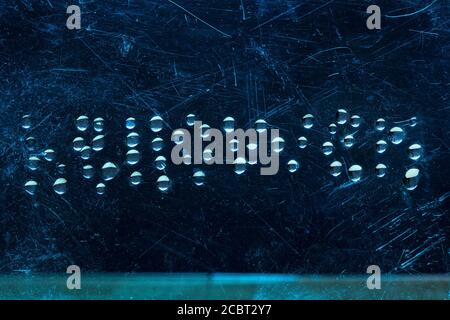 Wort halloween aus Wassertropfen auf einem zerkratzten dunklen Glas fantastische Abstraktion Stockfoto