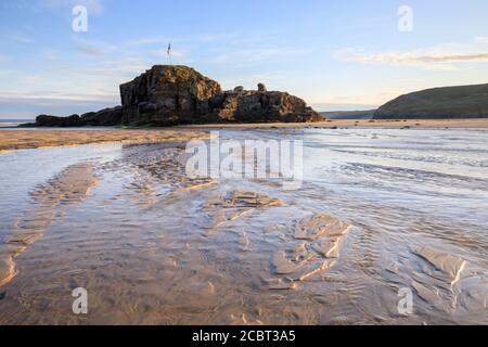 Chapel Rock am Perranporth Beach in Cornwall, aufgenommen an einem Morgen Mitte Juli mit Sandmustern als Vordergrund-Interesse. Stockfoto