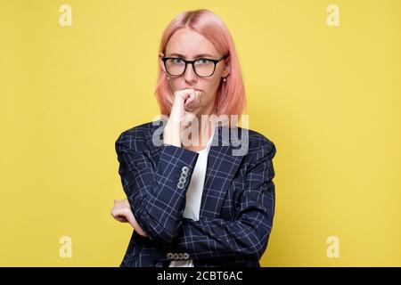 Junge Geschäftsfrau halten ihren Finger an ihr Kinn machen ein Harte Entscheidung Stockfoto