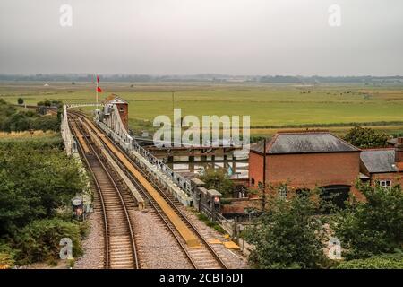 Die Eisenbahnschwingenbrücke über den Fluss Yare im Dorf Reedham im Norfolk Broads National Park. Gefangen von oben stehend auf dem Ziegel Stockfoto