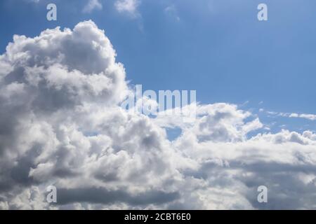 Schöne flauschige weiße schöne Wolkenformationen in einem tiefblauen Sommerhimmel Stockfoto
