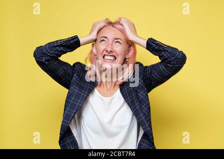 Upset and angry woman screaming holding hands on head. Stockfoto