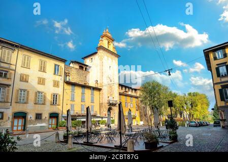 Stadtbild mit Straßencafé und Blick auf den historischen Uhrenturm Palazzo Roncalli in Bergamo. Lombardei, Italien Stockfoto