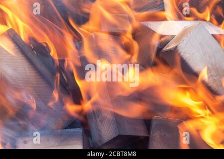 Die Flamme des Feuers ist außer Fokus. Brennendes Holz im Grillofen. Alles ist verderblich - ein Konzept. Stockfoto