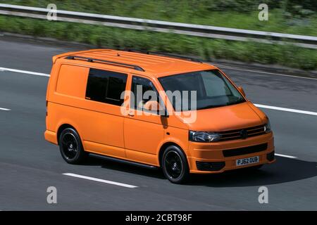 2013 Volkswagen VW Transporter T32 140 TDI SWB Orange LCV Panel Van Diesel Fahren auf der Autobahn M6 bei Preston in Lancashire, UK. Stockfoto