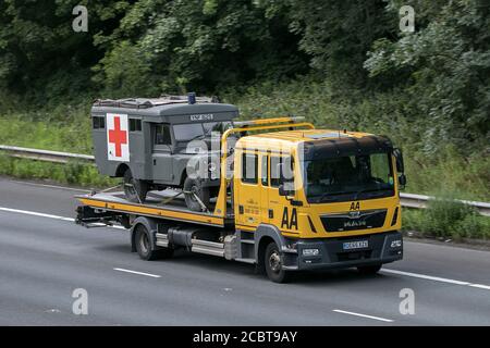 AA Van Bergewagen mit 1997 Land Rover Military Army Ambulanz auf der Autobahn M6 in der Nähe von Preston in Lancashire, Großbritannien. Stockfoto