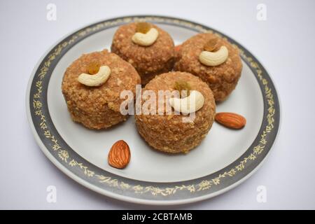 Nahaufnahme von Laddu oder ladoos aus Weizenmehl und Butterghee in Teller serviert während des Festivals wie Ganesh chaturthi prasad, diwali dekorieren Stockfoto