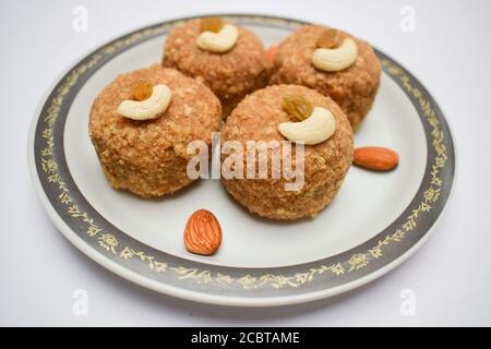 Nahaufnahme von Laddu oder ladoos aus Weizenmehl und Butterghee in Teller serviert während des Festivals wie Ganesh chaturthi prasad, diwali dekorieren Stockfoto