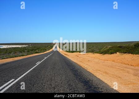 Blick auf eine leere Straße mit rotem Boden in der Nähe von Shell Strand in Western Australia Stockfoto
