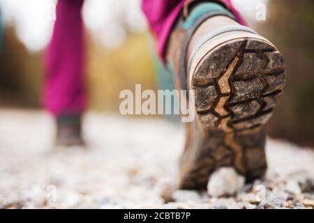 Wandern Mädchen in der Natur. Low-Angle-Ansicht von allgemeinen Sportschuh und Beine auf Kiesel Schotterstraße. Gesunder Fitness-Lebensstil im Freien. Stockfoto