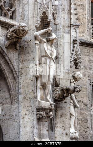 Rathaus aus der Nähe in München, Deutschland, Europa. Detail gotischer Baumauer mit Statuen und Wasserspeier im alten Münchner Stadtzentrum. Mari Stockfoto