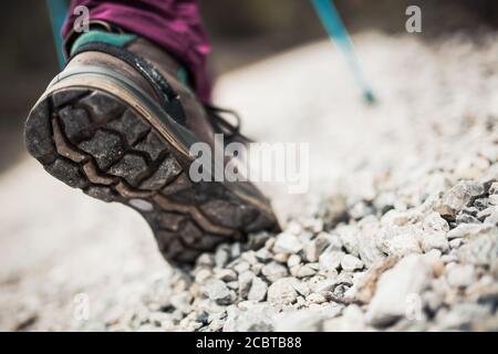 Wandern Mädchen in der Natur. Low-Angle-Ansicht von allgemeinen Sportschuh und Beine auf Kiesel Schotterstraße. Gesunder Fitness-Lebensstil im Freien. Stockfoto