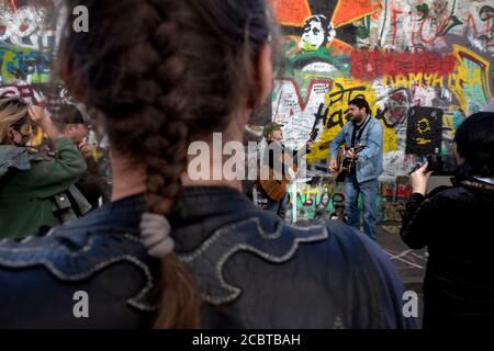 Moskau, Russland. 15. August 2020 EIN kleiner Fan von Viktor Tsoi singt ein Lied mit Gitarre auf dem Hintergrund der Tsoi-Mauer in der Arbat-Straße in Moskau am 30. Todestag des Sängers, Russland. Die Tsoi Wall ist eine mit Graffiti bedeckte Wand in Moskau, die dem Musiker Viktor Tsoi und seiner Band Kino gewidmet ist Stockfoto