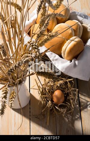 Frische, weiche Brioche-Brötchen in einem Korb auf Holzhintergrund. Scharfes Licht für sonnige Sommer Erntestimmung. Stockfoto