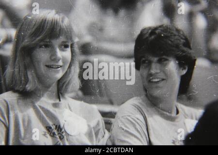 Feine Schwarz-Weiß-Fotografie aus den 1970er Jahren von zwei Teenagern, die auf ihren Sitzen sitzen, während sie miteinander gabbing. Stockfoto