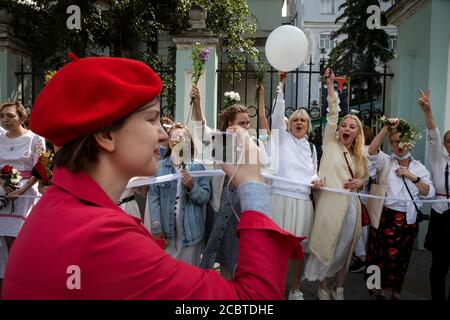 Moskau, Russland. 15. August 2020 Frauen mit Blumen und einem weißen Band, dem Symbol der Oppositionsbewegung, während einer Kundgebung gegen die Ergebnisse der weißrussischen Präsidentschaftswahl vor der belarussischen Botschaft in Moskau, Russland Stockfoto