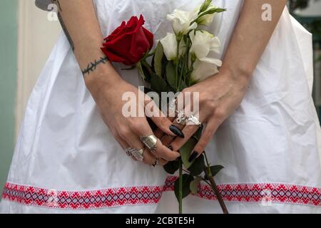 Moskau, Russland. 15. August 2020 Frauen halten Blumen, während sich Menschen, einige von ihnen ethnische Belarussen, zu einer Kundgebung gegen die Ergebnisse der weißrussischen Präsidentschaftswahl vor der belarussischen Botschaft in Moskau, Russland, versammeln. Rund 400 Menschen, meist Frauen, stehen in der Maroseyka-Straße in der Nähe der belarussischen Botschaft in Solidarität mit den Demonstranten, die bei den jüngsten Kundgebungen in Belarus verletzt wurden Stockfoto