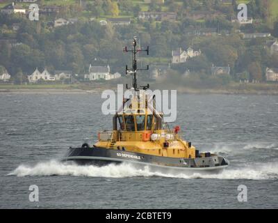 SD Dependable, ein von Serco Marine Services betriebenes Schlepper, das Gourock passiert, um den USNS Zeus (T-ARC-7) der US Navy nach Faslane zu eskortieren. Stockfoto