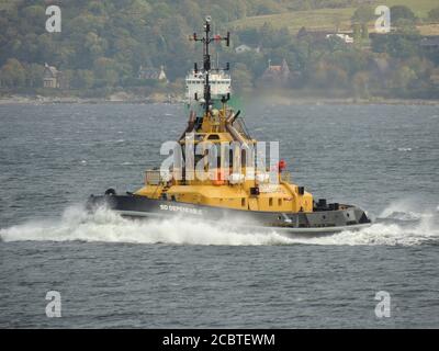 SD Dependable, ein von Serco Marine Services betriebenes Schlepper, das Gourock passiert, um den USNS Zeus (T-ARC-7) der US Navy nach Faslane zu eskortieren. Stockfoto