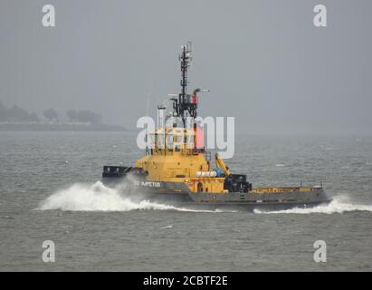 SD Impetus, ein von Serco Marine Services betriebenes Schlepper, das Gourock passiert, um den USNS Zeus (T-ARC-7) der US Navy nach Faslane zu eskortieren. Stockfoto