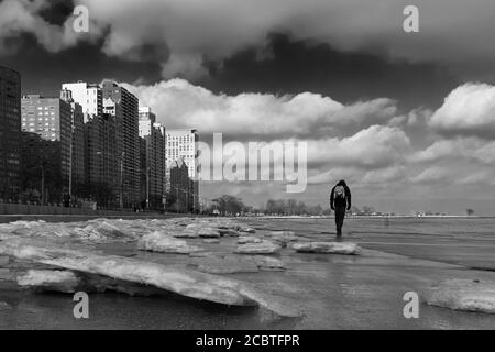 Mann, der alleine entlang des eisigen Chicagoer Seeufer läuft Stockfoto