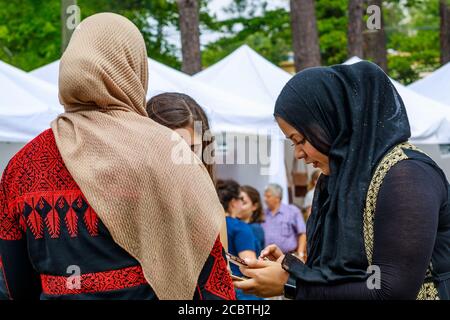 Gruppe muslimischer Frauen, die Technologie auf einem arabischen Festival nutzen. Stockfoto