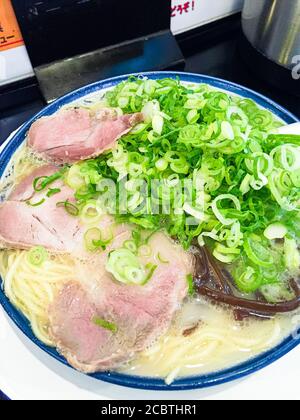 Nahaufnahme von japanischem gegrilltem Char siu-Schweinefleisch-Ramen-Nudeln in Schweineknochenbrühe und gekrönt mit Frühlingszwiebeln.Nishijin Shopping District in Fukuoka. Stockfoto