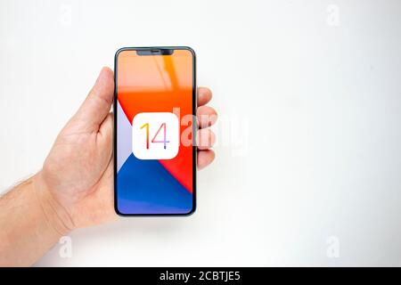 Calgary, Alberta, Kanada. August 15 2020. Eine Person, die ein iPhone 11 Pro Max mit dem iOS 14 Logo hält Stockfoto