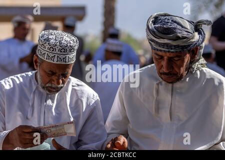 Omanische Männer tauschen Geld Stockfoto