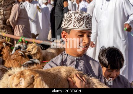 Kinder, die an den Freitagsversteigerungen bei Nizwa Souq teilnehmen Stockfoto