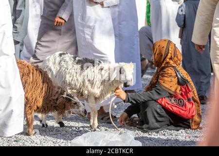 Omani Dame trägt Abaya Verkauf Ziege an der Nizwa Fort Stockfoto