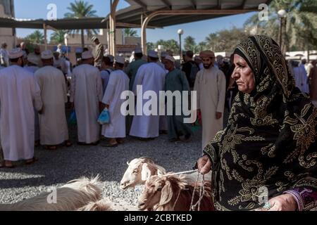 Omani Dame trägt Abaya Verkauf Ziege an der Nizwa Fort Stockfoto