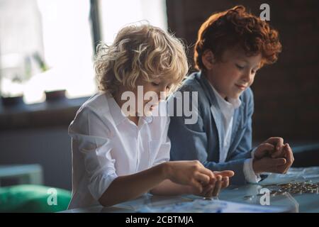 Zwei Jungen zählen Münzen und suchen beteiligt Stockfoto