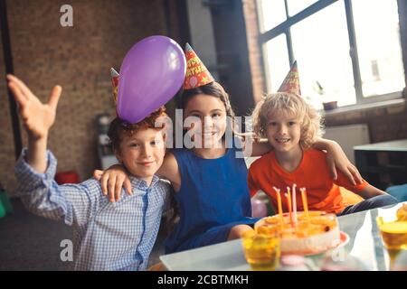 Drei Kinder feiern den Geburtstag und fühlen sich glücklich Stockfoto