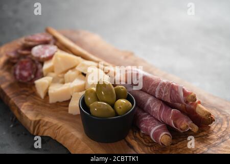 Italienische Snacks auf olivem Holzbrett, flacher Fokus Stockfoto