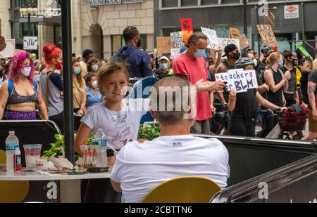 Chicago, Illinois, USA. August 2020. Ein junges Mädchen stiguliert einer Menge von Anti-Polizei-Demonstranten, während sie in einem Café in Chicago sitzt. Kredit: Dominic Gwinn/ZUMA Wire/Alamy Live Nachrichten Stockfoto